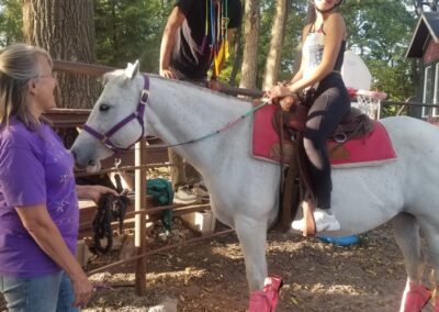 Girl on horse with excited Dad